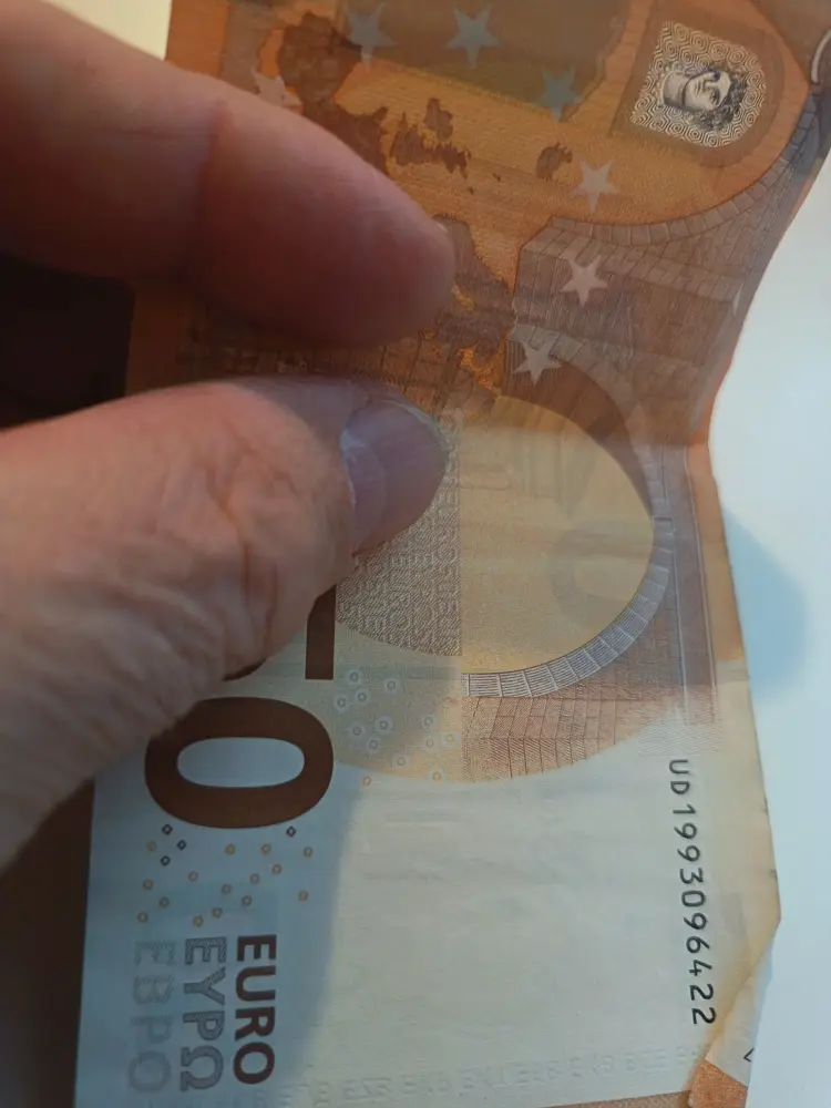 Matka 8.9.-1.10.2025 3 Viiden kymmenen euron seteli kädessä.